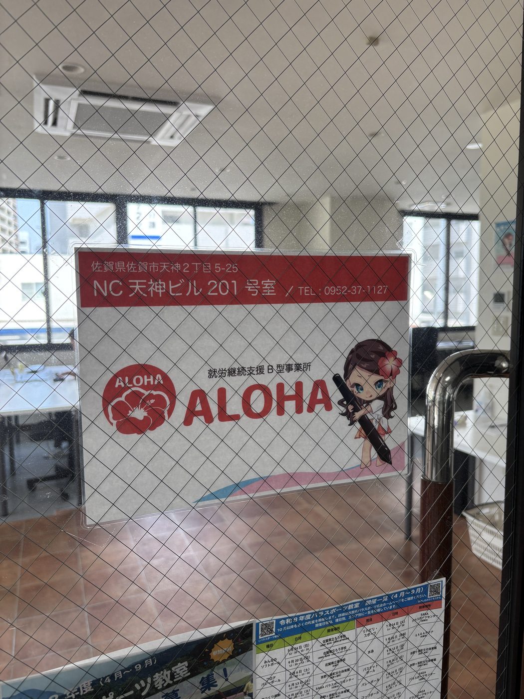 佐賀市天神のNC天神ビル201号室、扉に掲示された就労継続支援B型ALOHAの案内サイン