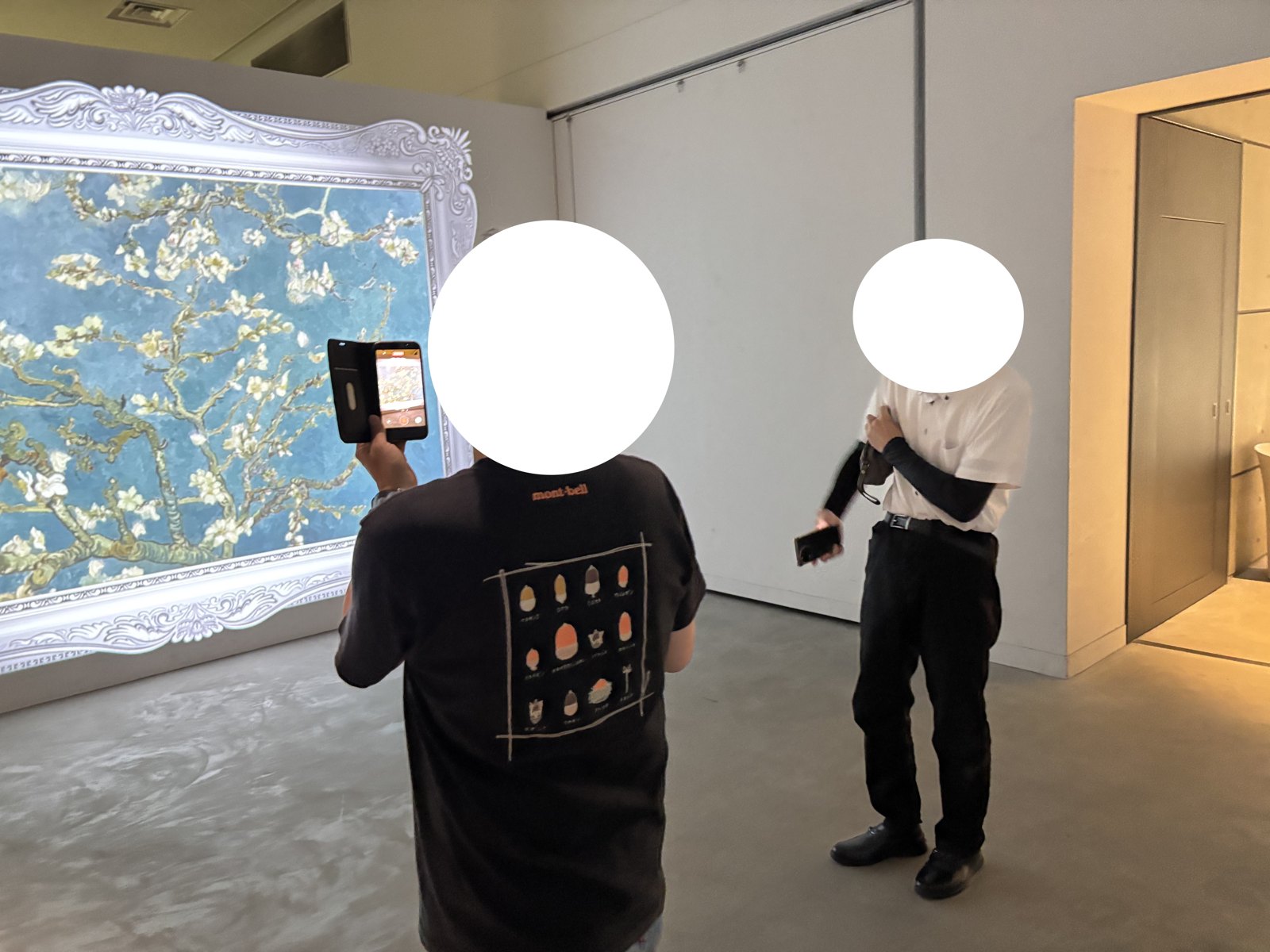 花を描いた映像が広がる展示室で作品を鑑賞する様子