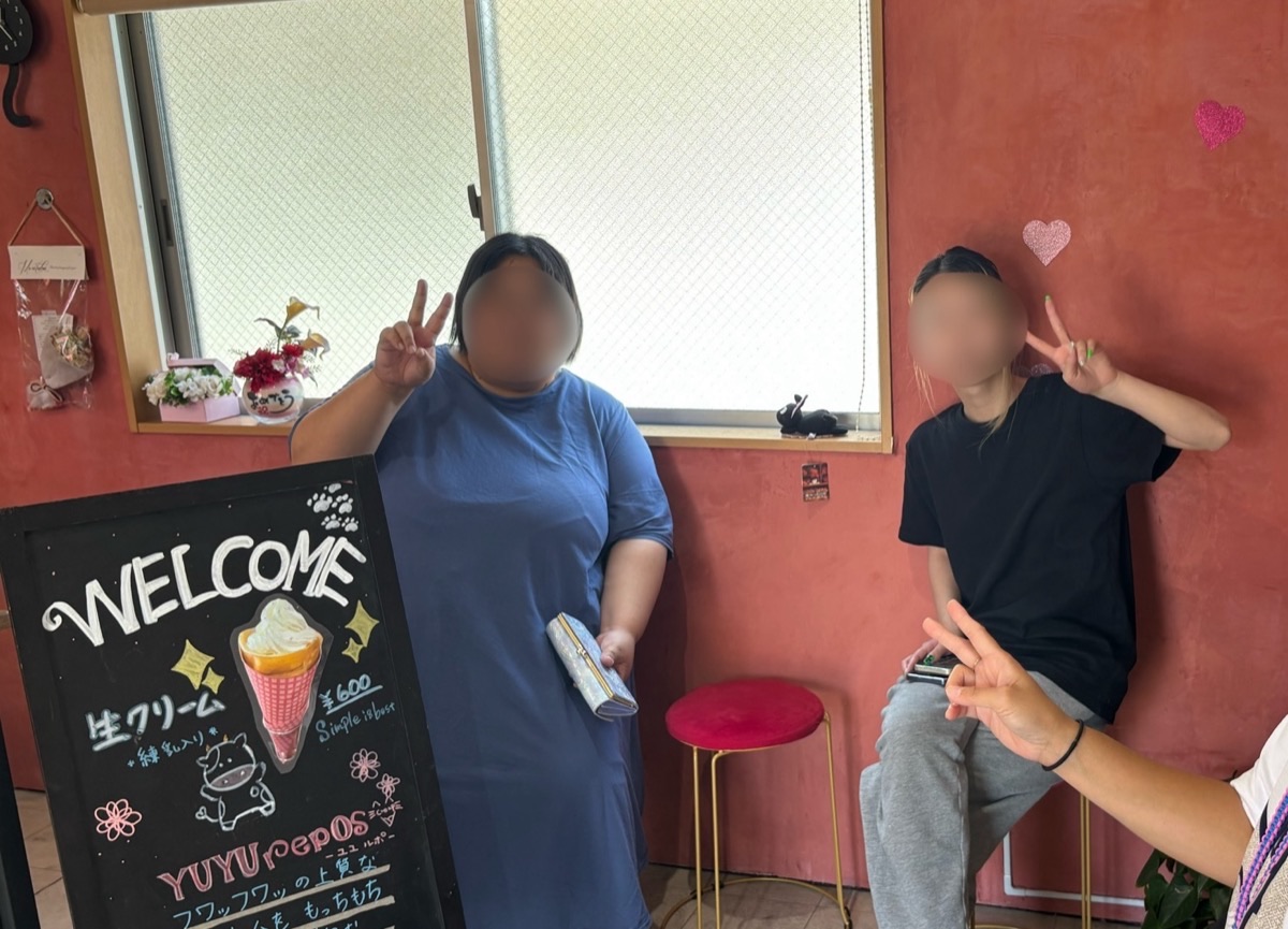 佐賀ALOHAの利用者様が、外出レクリエーションでクレープ店を訪れ、笑顔でポーズをとる様子